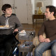 Trevor and Ben sitting in the living room in the movie The Fundamentals of Caring.