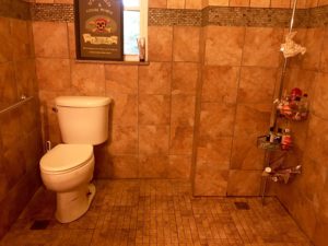 Toilet with a 3 foot wide space beside it to accommodate a wheelchair.